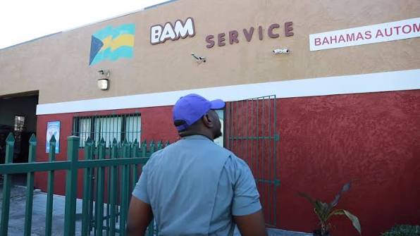 BAM Service building exterior with the Bahamas flag and green entrance gate on Abundant Life Road